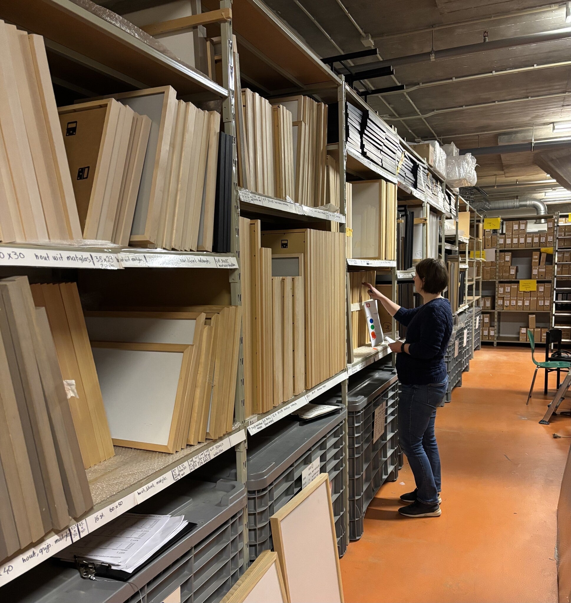 Foto van een medewerken van MuseumDepotShop in het depot van het Nederlands Fotomuseum